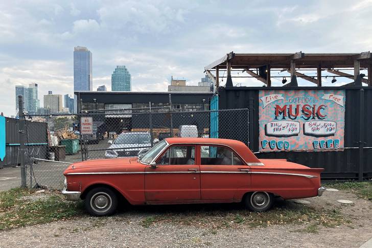 a broken down red car parked in Long Island City
